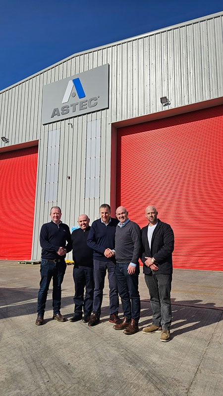 Astec representatives in front of Astec building with new dealer partners