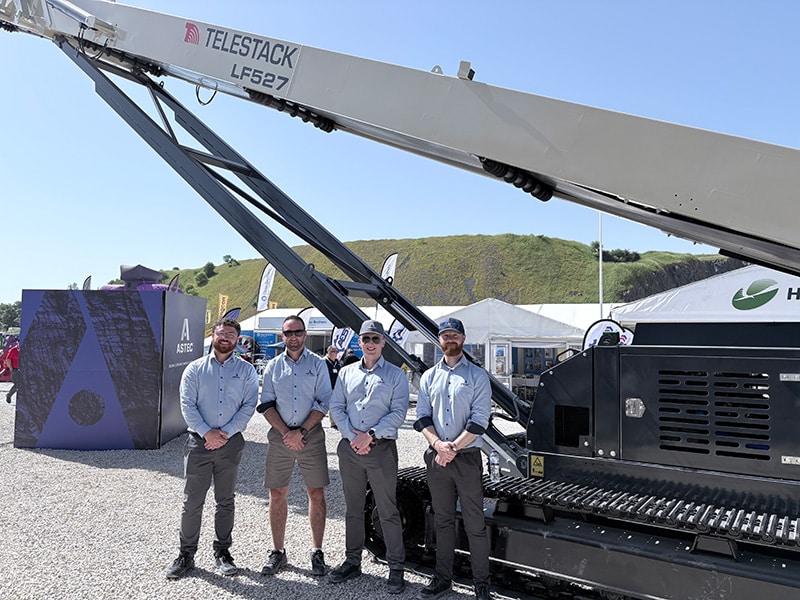 Quatre membres de l'équipe Telestack posant devant un alimentateur à faible portée Telestack LF527 lors du salon Hillhead 2026